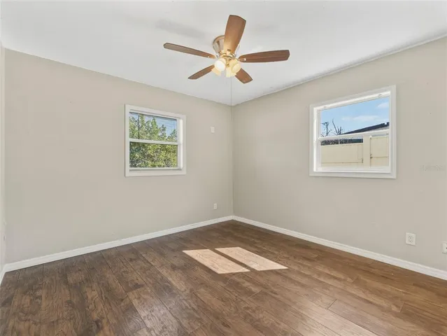 a view of empty room with wooden floor