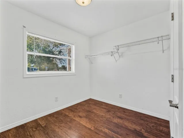a view of a big room with wooden floor and windows