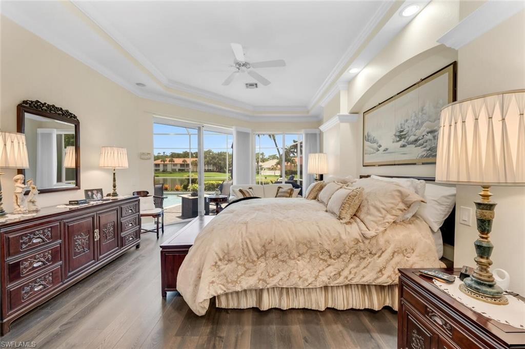 1624 Manchester Court Naples, FL 34109 - Photo 15 of 30 a bedroom with a large bed and a flat tv screen on dresser