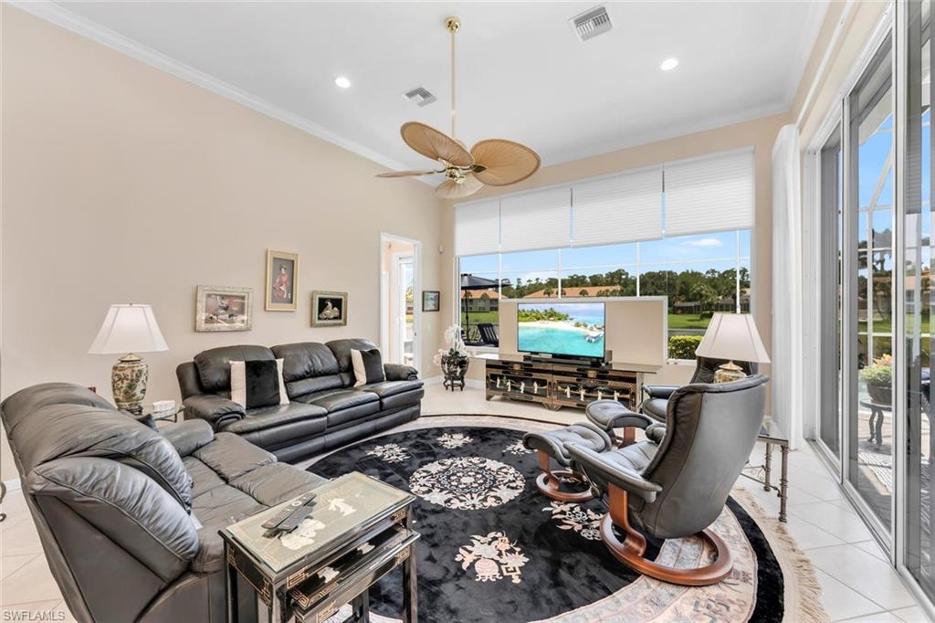 1624 Manchester Court Naples, FL 34109 - Photo 7 of 30 a living room with furniture a flat screen tv and a large window