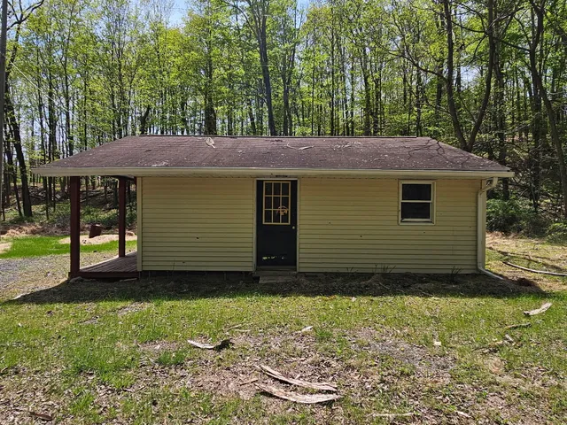 a view of a house with a yard and large tree
