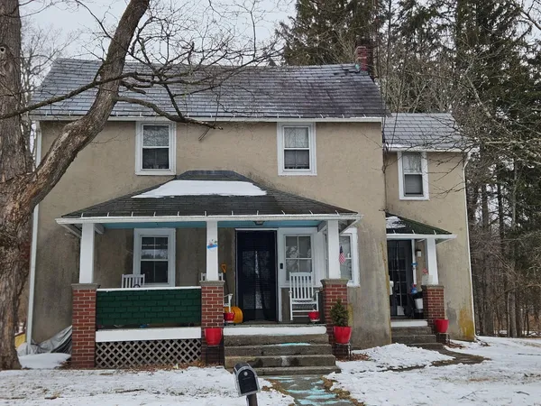 a front view of a house with a tree