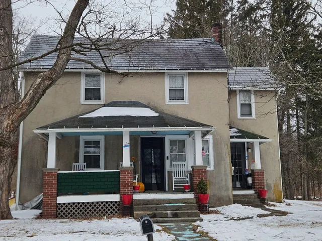 a front view of a house with a tree