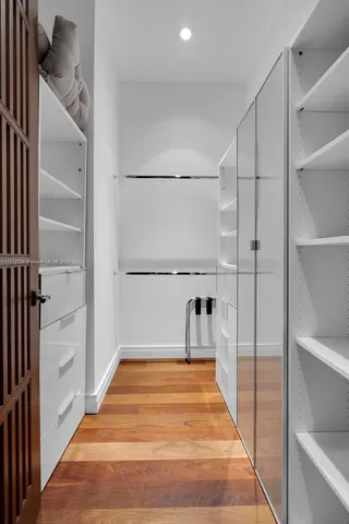 a view of a hallway with furniture and wooden floor