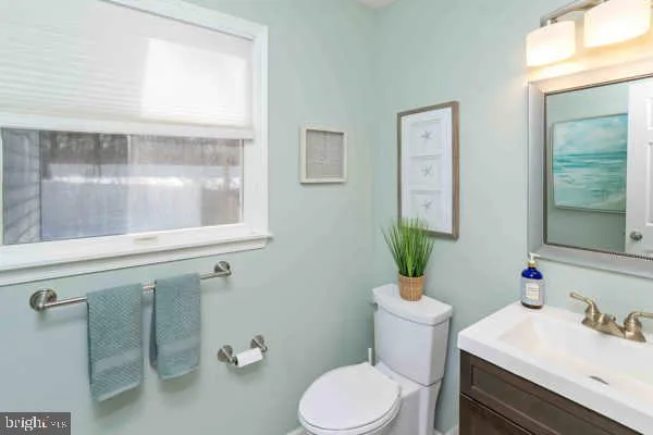 a bathroom with a toilet a sink a tub and mirror