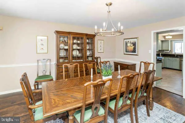 a view of a dining room with furniture a chandelier and wooden floor