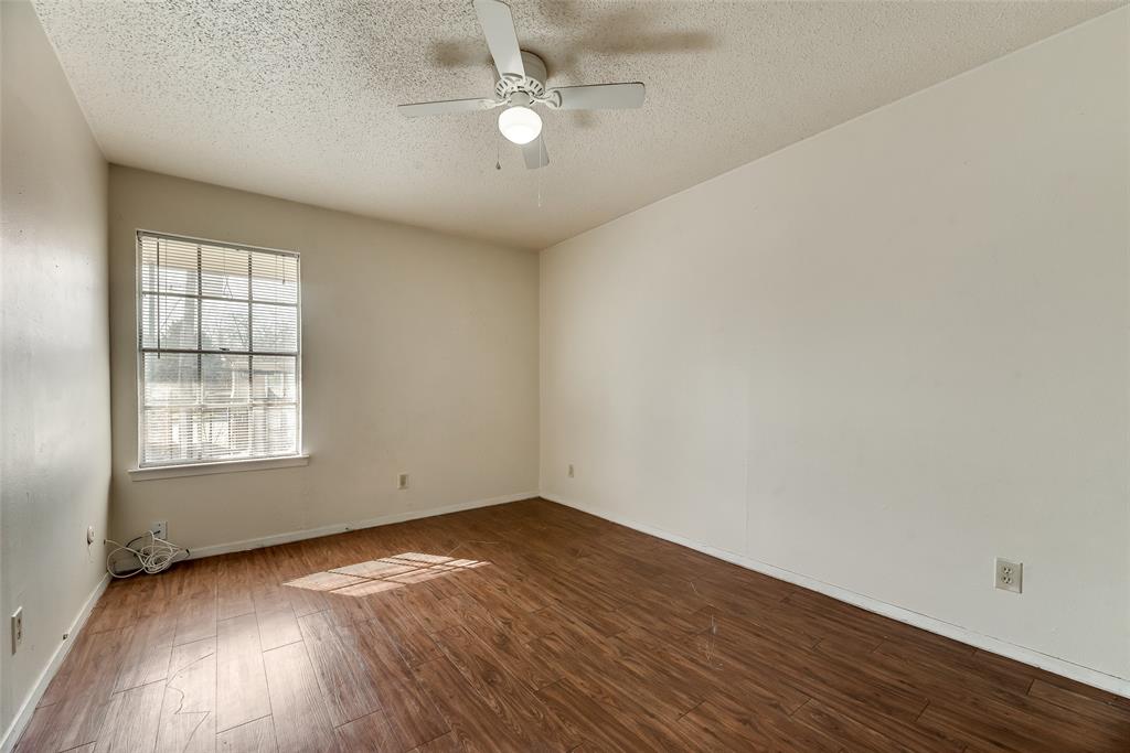 106 East Cedar Street, Unit 12 Arlington, TX 76011 - Photo 14 of 18 an empty room with wooden floor chandelier fan and windows