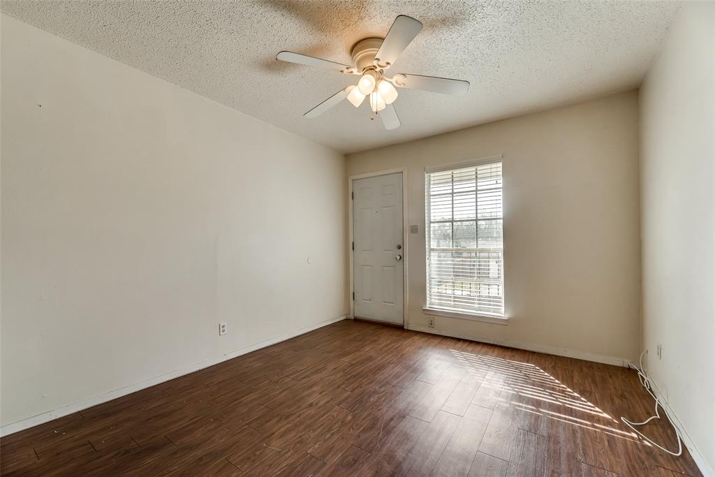 106 East Cedar Street, Unit 12 Arlington, TX 76011 - Photo 6 of 18 an empty room with wooden floor and windows