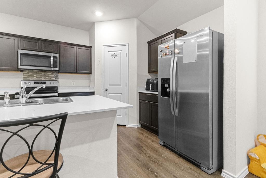 2928 Roper Street Royse City, TX 75189 - Photo 11 of 26 a kitchen with stainless steel appliances a refrigerator and a stove top oven
