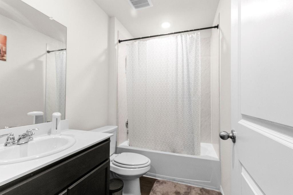 2928 Roper Street Royse City, TX 75189 - Photo 15 of 26 a bathroom with a sink a toilet a mirror and shower
