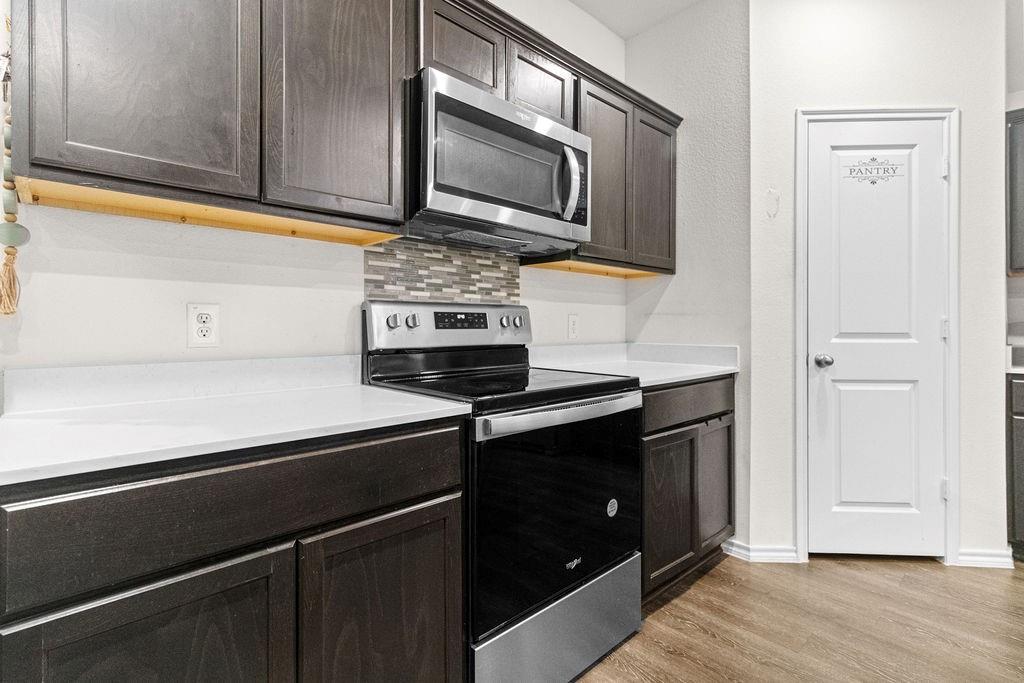 2928 Roper Street Royse City, TX 75189 - Photo 6 of 26 a kitchen with stainless steel appliances a stove microwave and cabinets