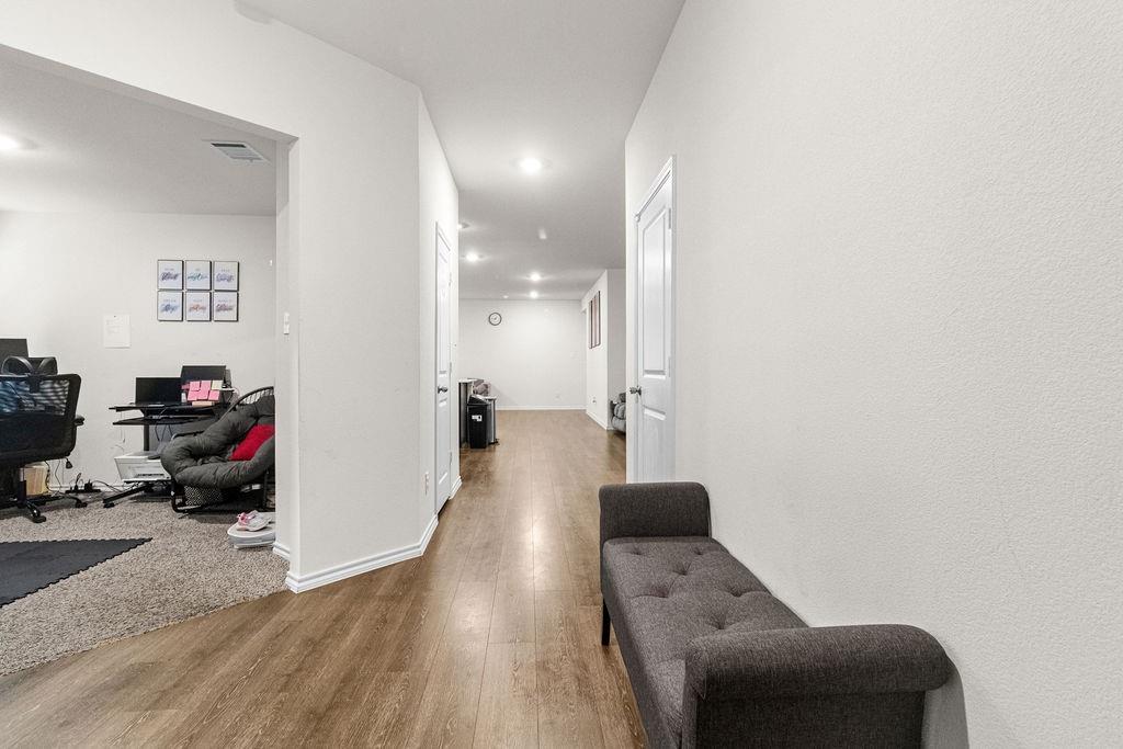 2928 Roper Street Royse City, TX 75189 - Photo 7 of 26 a view of a hallway with couch and wooden floor