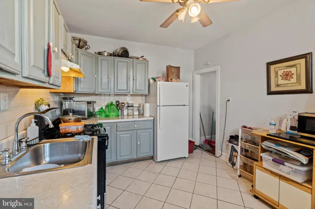 a kitchen with a refrigerator sink and white cabinets