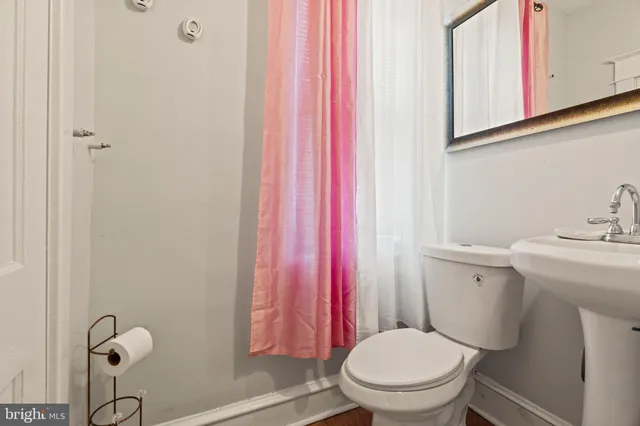 a bathroom with a toilet a sink and a window