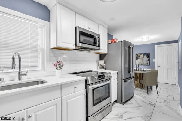 a kitchen with stainless steel appliances a stove microwave and refrigerator