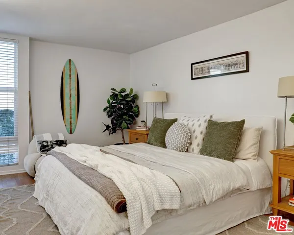 a bedroom with bed and a painting