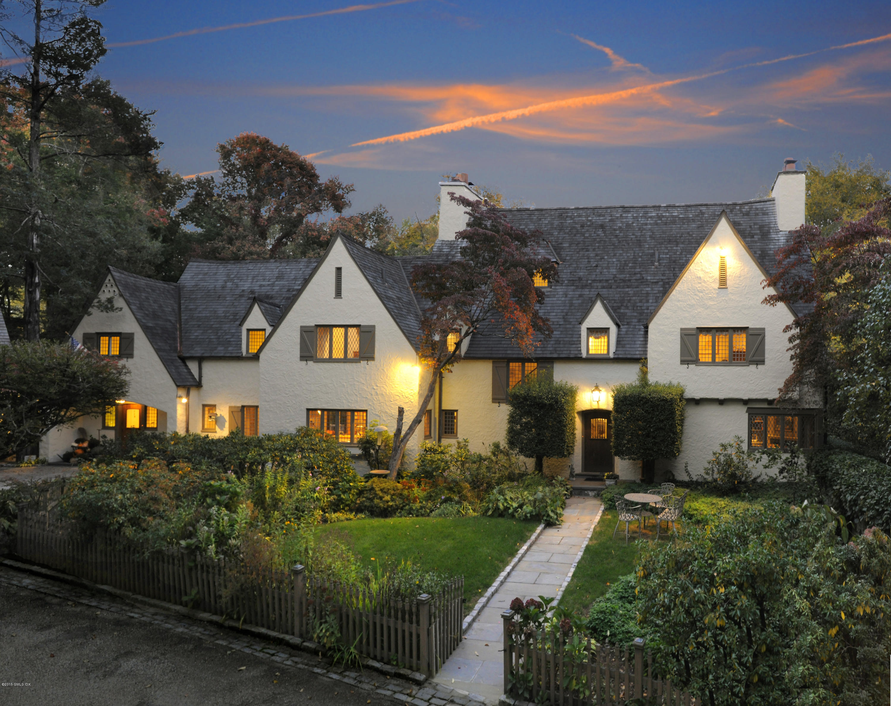 a front view of a house with a yard and outdoor seating
