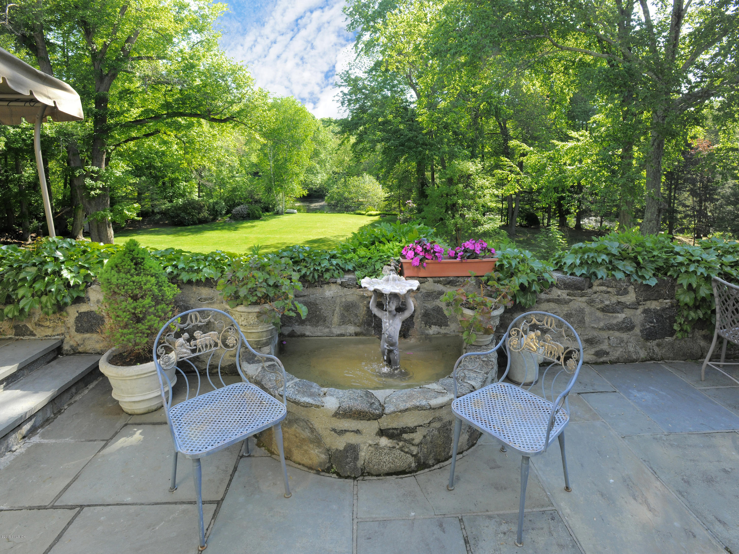 9 Frost Road Greenwich, CT 06830 - Photo 19 of 29 a view of a backyard with table and chairs and potted plants