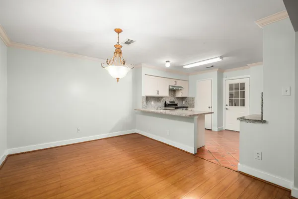 a kitchen with a refrigerator and white cabinets