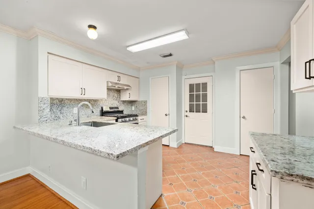 a view of a kitchen with a sink dishwasher stove and wooden cabinets