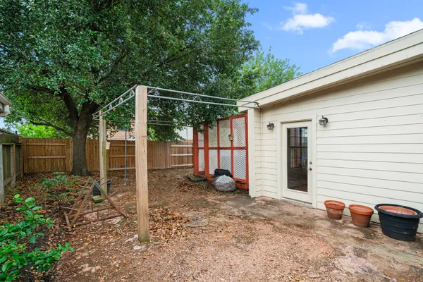 a backyard of a house with potted plants and a tree