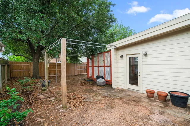 a backyard of a house with potted plants and a tree