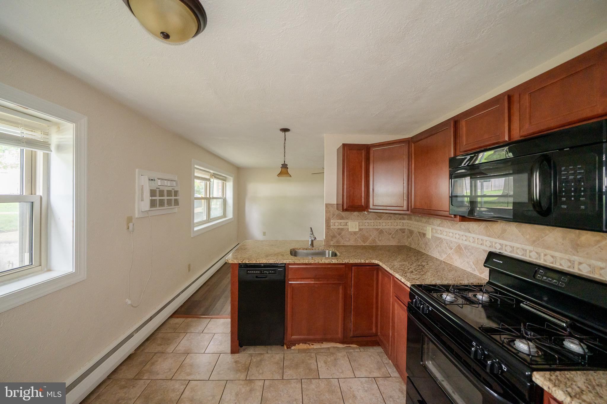 231 Sharpless Street, Unit 1D West Chester, PA 19382 - Photo 4 of 11 a kitchen with granite countertop a stove and a sink