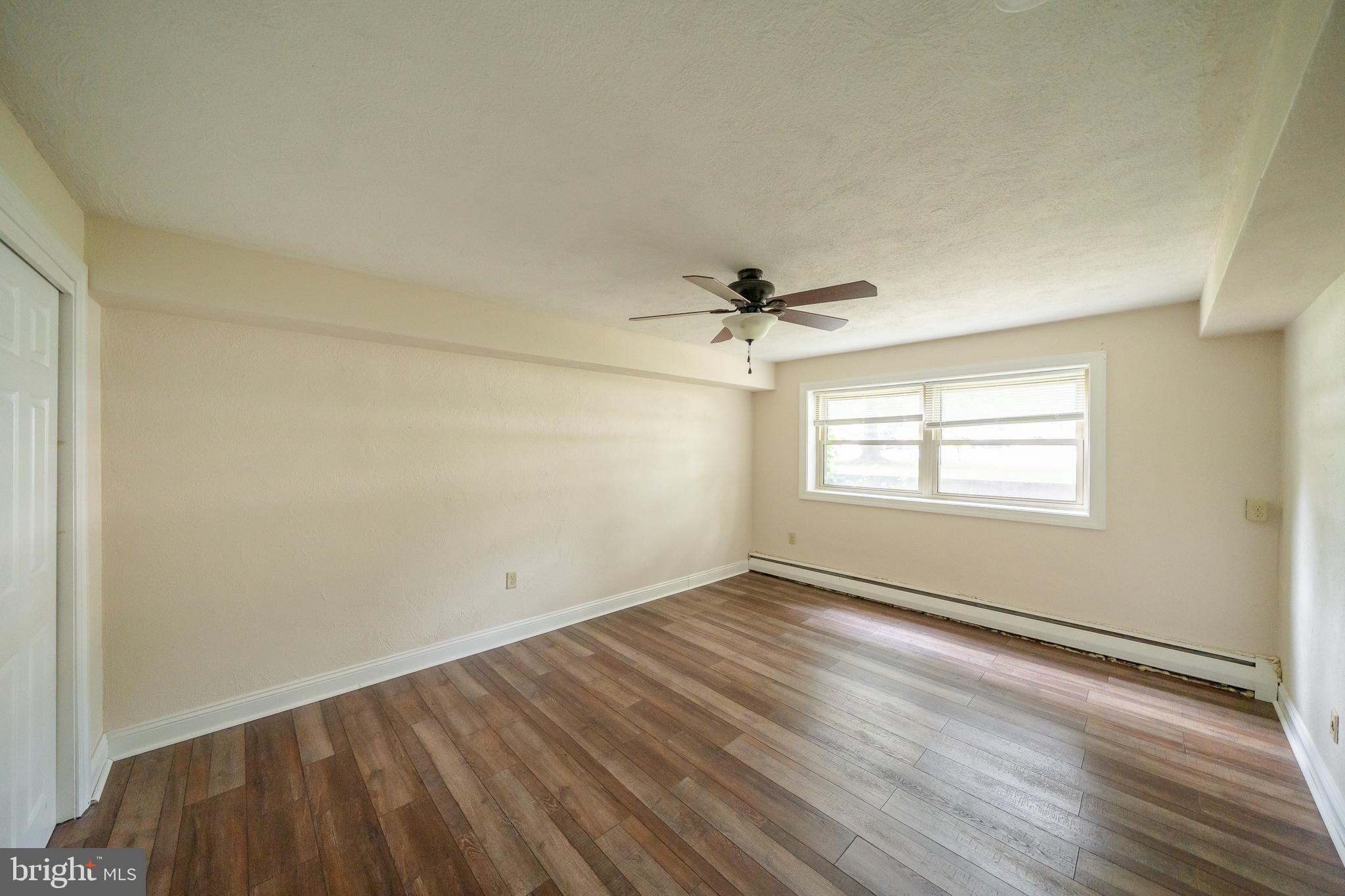 231 Sharpless Street, Unit 1D West Chester, PA 19382 - Photo 7 of 11 an empty room with wooden floor fan and windows