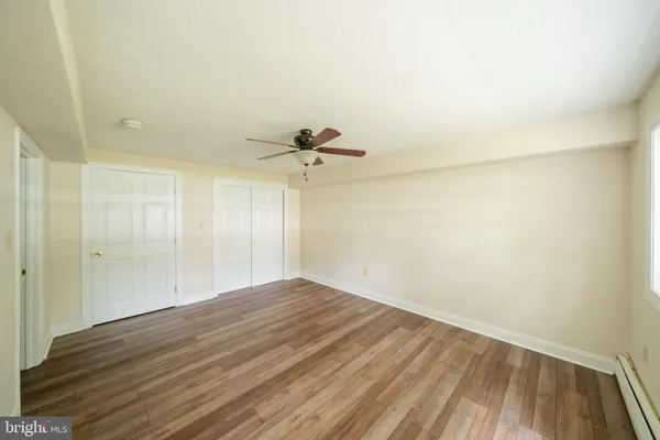 a view of empty room with wooden floor