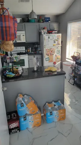 a living room with couches chairs and kitchen view