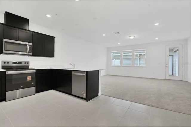 a kitchen with stainless steel appliances a refrigerator sink and microwave