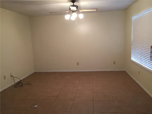 en empty room with windows and ceiling fan