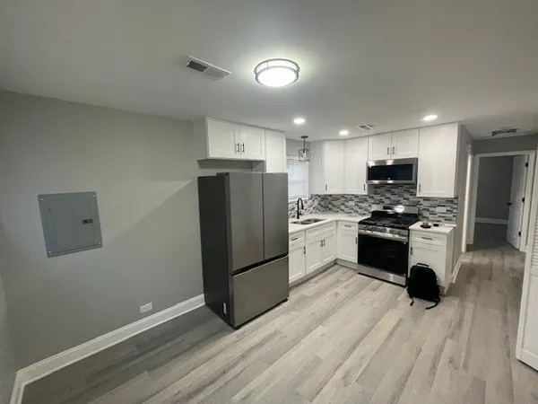 a kitchen with a refrigerator and a stove top oven