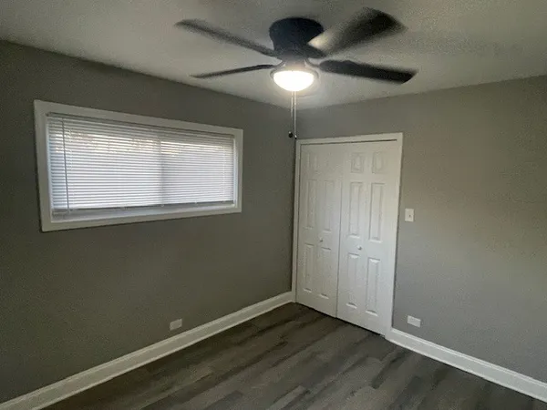 an empty room with a window and a fan