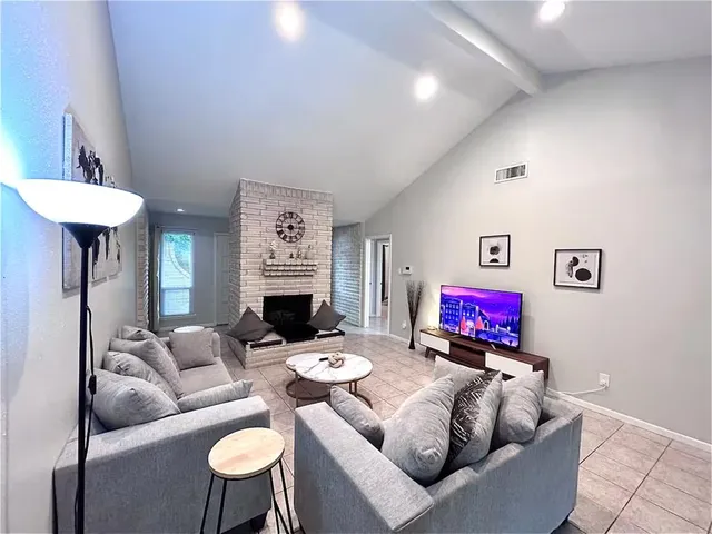 a living room with furniture a fireplace and a flat screen tv