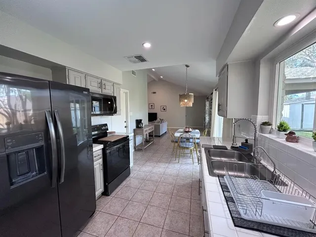 a large kitchen with a large counter top stainless steel appliances and cabinets