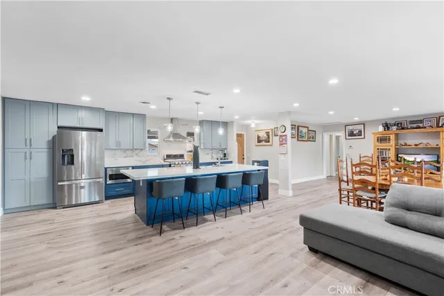 a living room with stainless steel appliances kitchen island granite countertop a couch and a view of kitchen