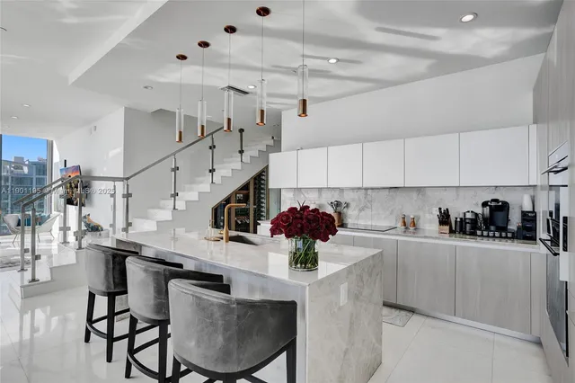 a kitchen with stainless steel appliances kitchen island a table and chairs in it