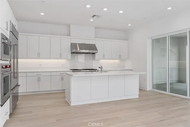 an empty room with wooden floor and entrance