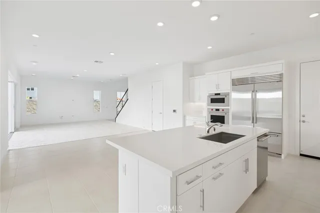 a kitchen that has a sink a counter and stainless steel appliances