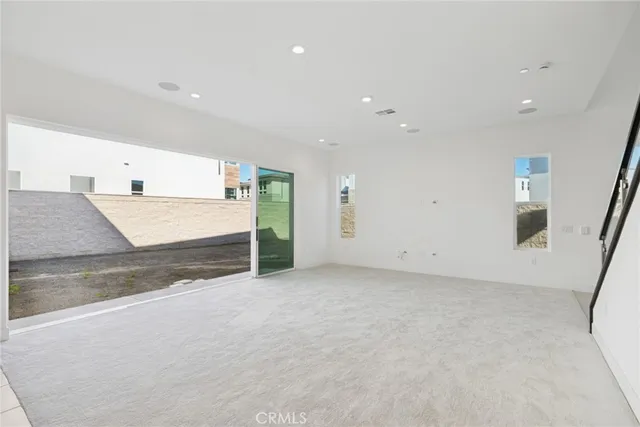 an empty room with mirror and stairs