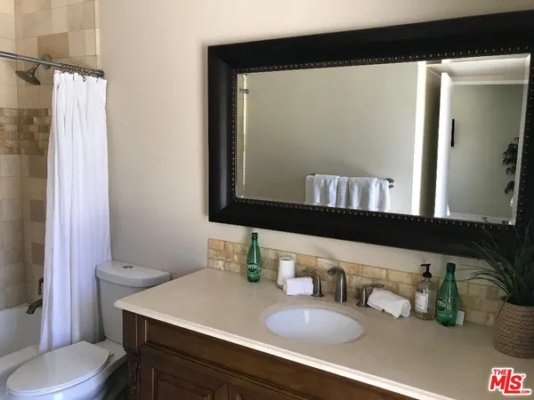 a bathroom with a sink vanity mirror and toilet