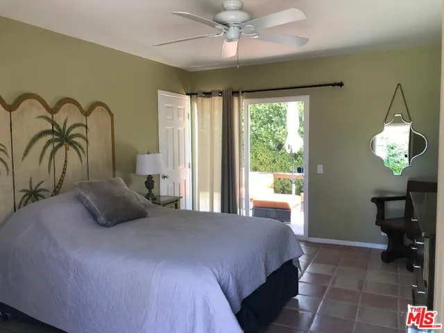 a bedroom with a bed a chandelier and a large window