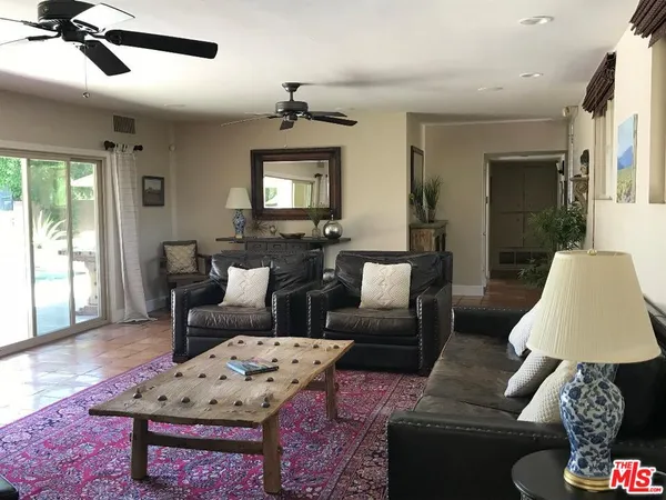 a living room with furniture a flat screen tv and a window