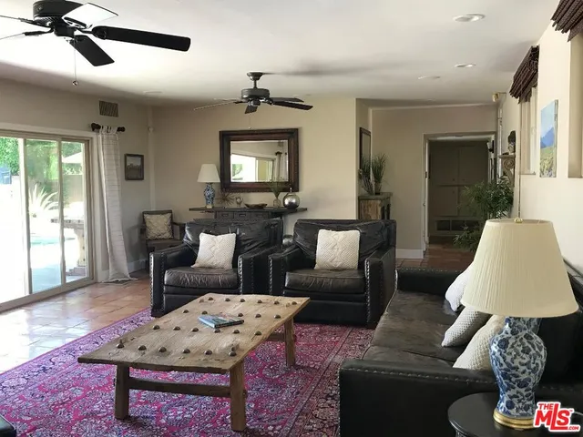 a living room with furniture a flat screen tv and a window