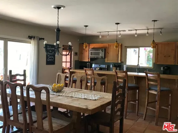 a view of a dining room and livingroom with furniture wooden floor a chandelier