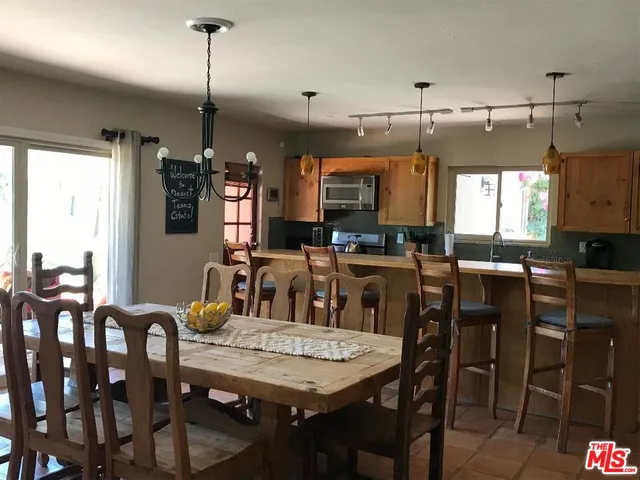 a view of a dining room and livingroom with furniture wooden floor a chandelier