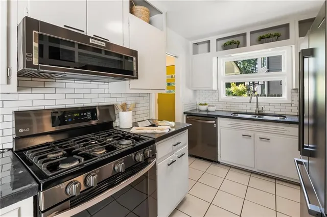 a kitchen with a stove a sink and wooden cabinets