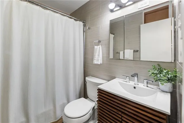 a bathroom with a sink a toilet and shower curtain