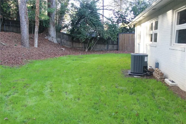 a view of a backyard with potted plants and large tree